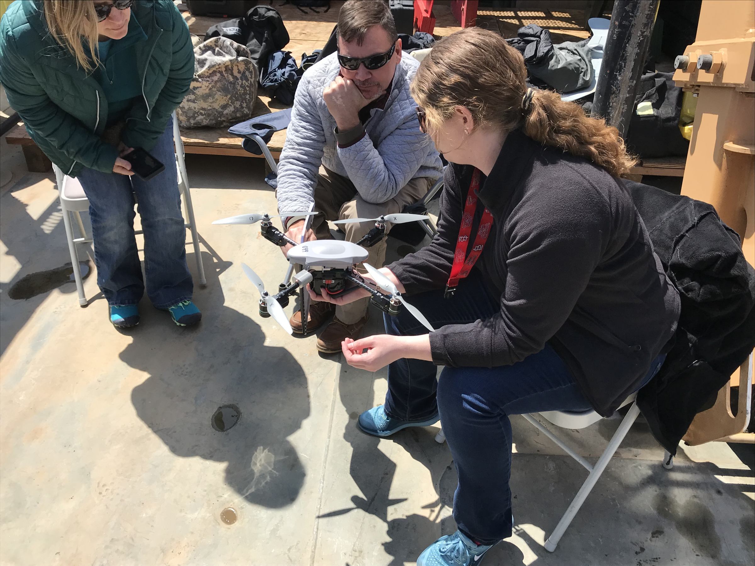 RASP crew at Singing River Island observe a quadcopter (four-propeller drone) ahead of a demonstration.