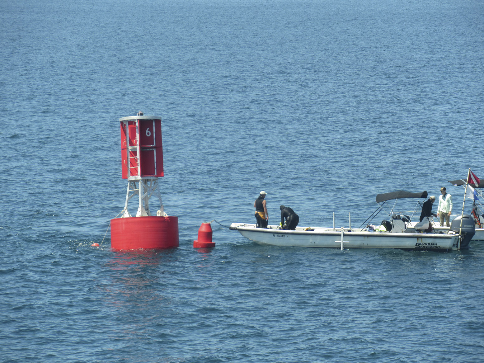 Divers prepare to go underwater for the fastening of the mooring line to its anchor.