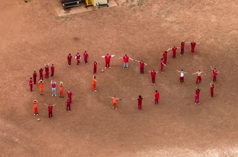 Tren de Aragua gang members form "SOS" using their bodies.