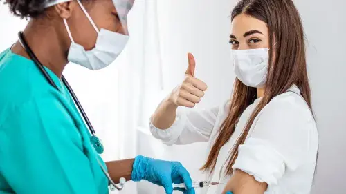 A nurse gives a woman a vaccine