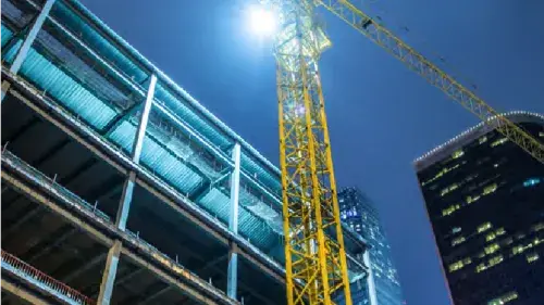 Building under construction with crane on the side 