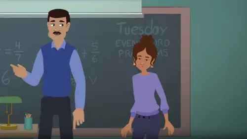 Mia has a conversation with their teacher in the classroom in front of the chalkboard.