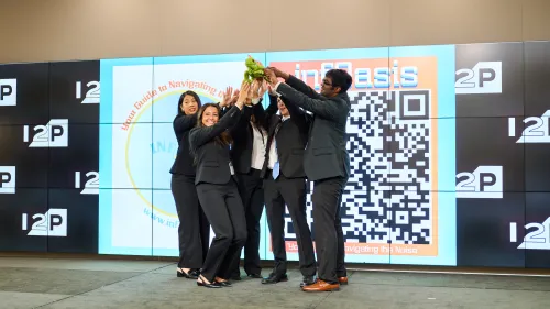 Image of the first place Invent 2 Prevent collegiate team, InfOasis, holding a stuffed turtle animal on the competition stage.