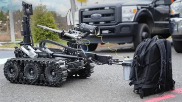 Robot checking out a black bookbag