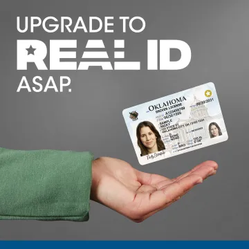 Upgrade to REAL ID ASAP. Hand holding an Oklahoma driver license card.